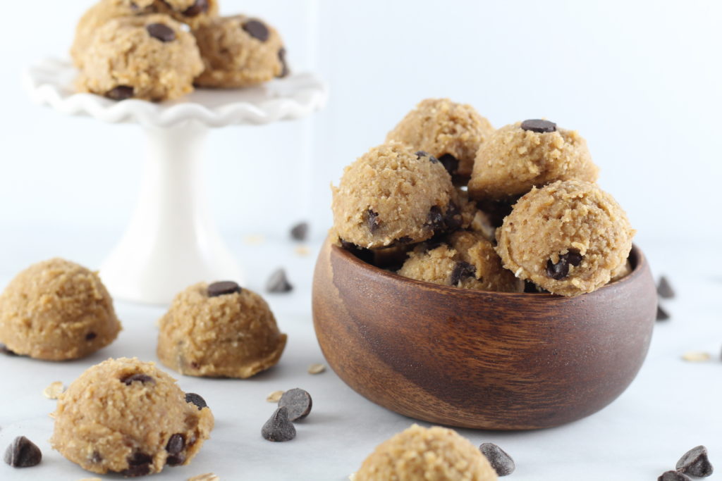 bowl of cookie dough bites and white cupcake pedestal