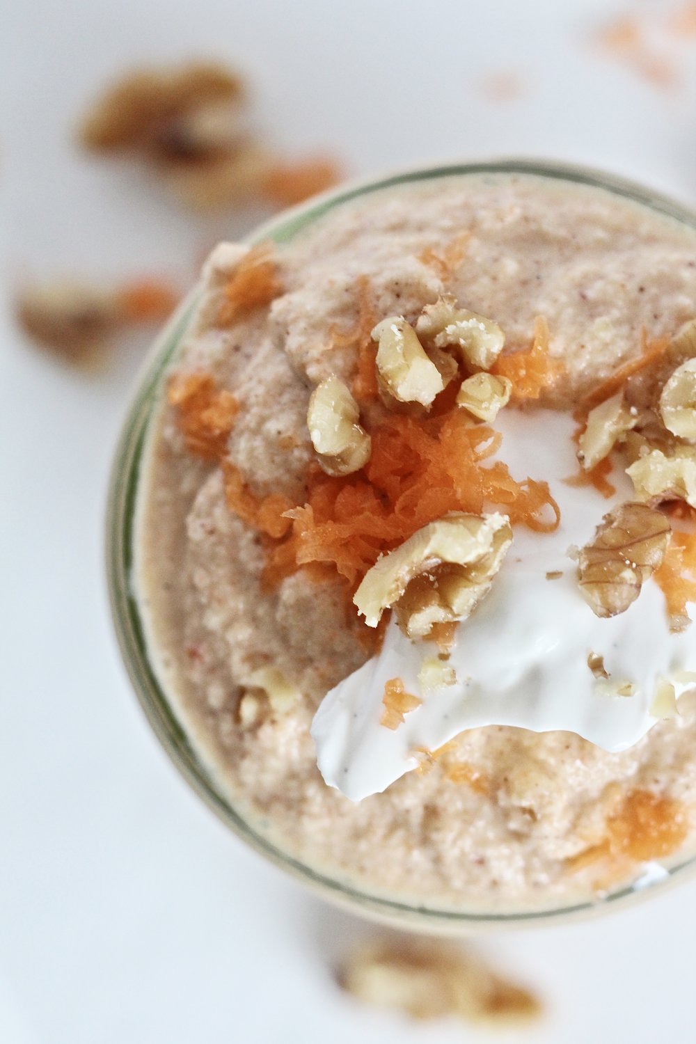 birds eye view of carrot cake smoothie topped with walnuts, carrots, and frosting