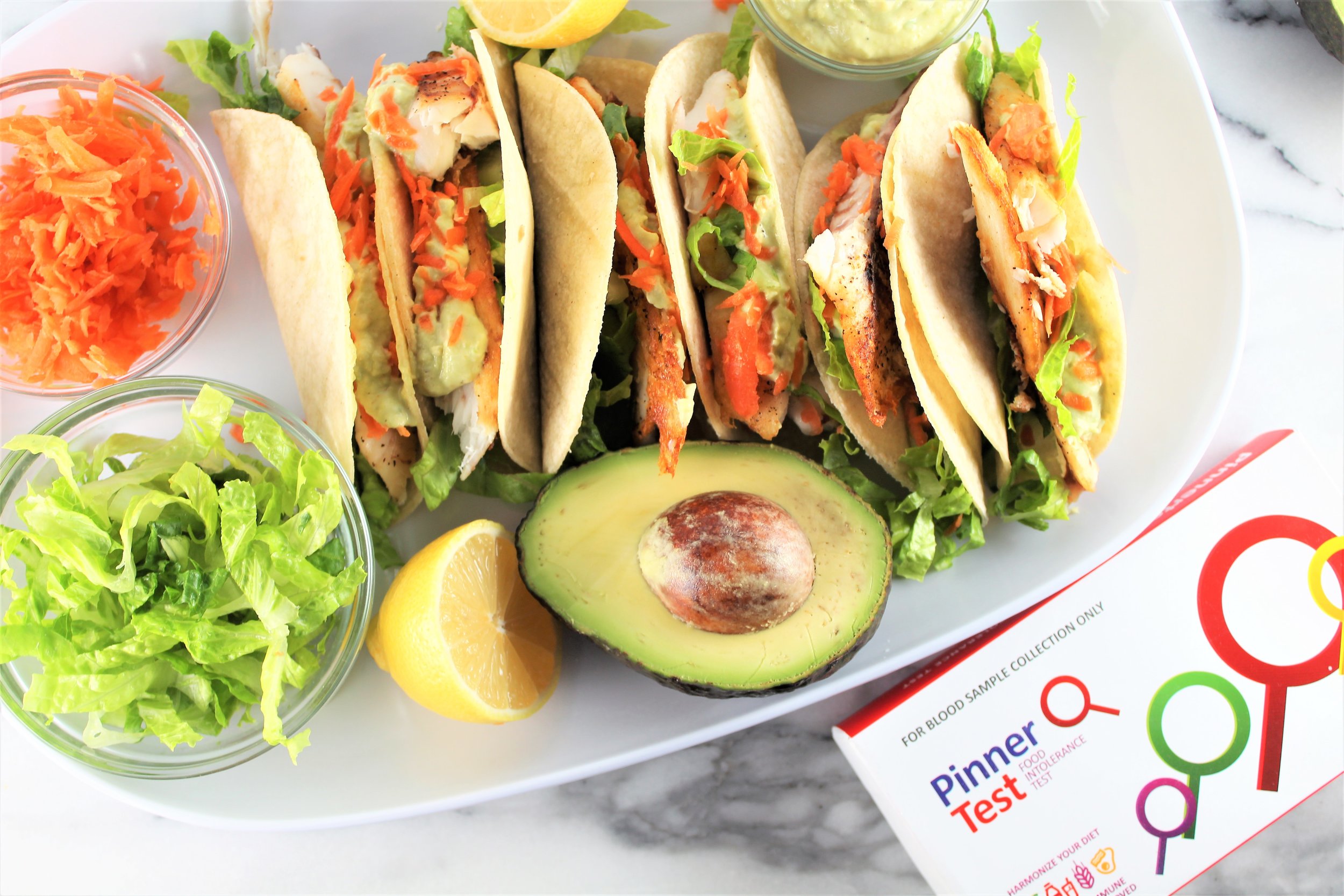 fish tacos with avocado, lettuce, carrots, and pinner test box