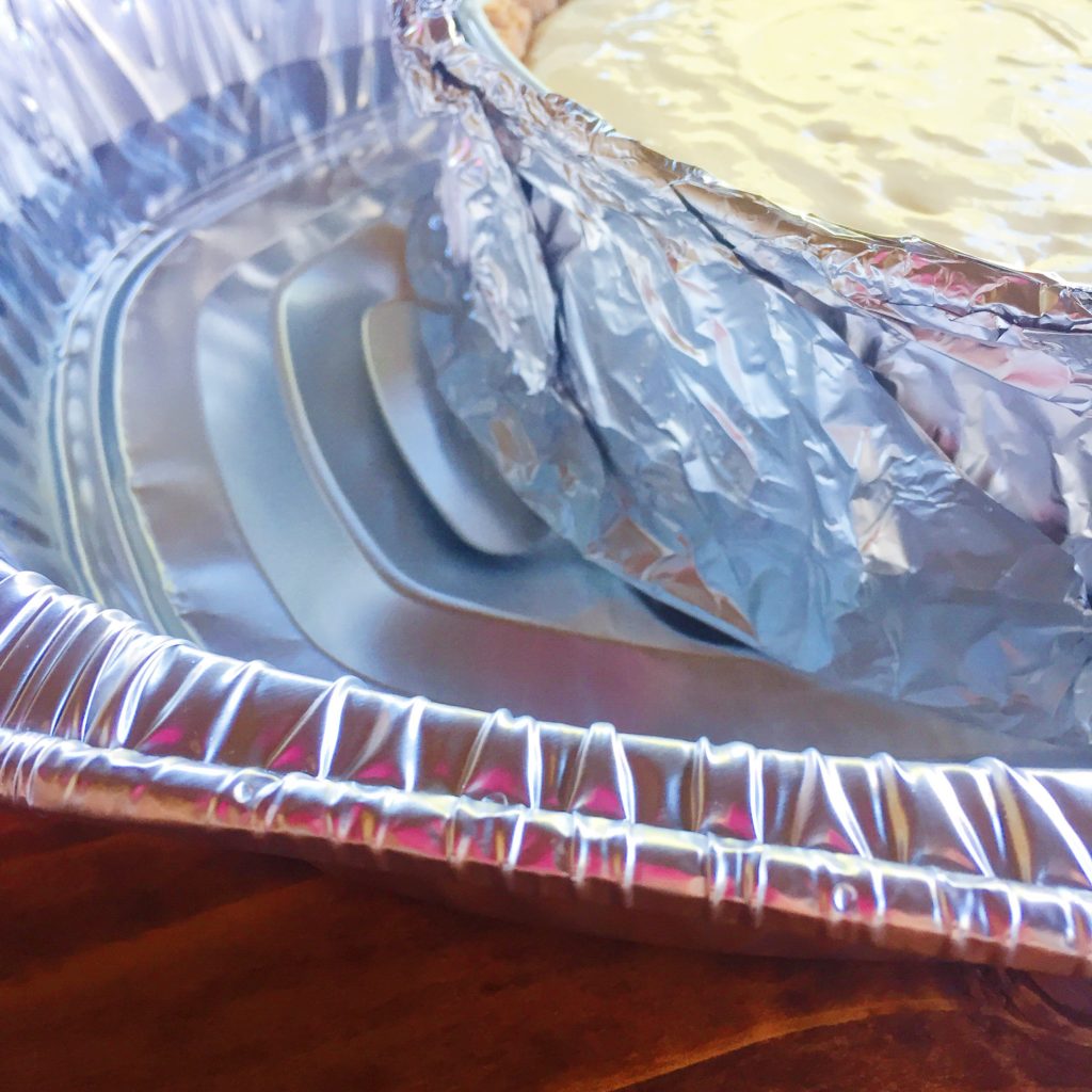 cheesecake making step with layers of aluminum pan