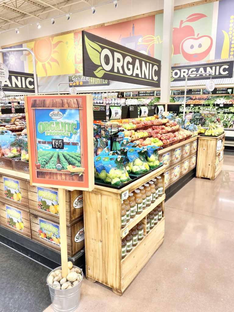 organic produce section sprouts with apples and apple juice and pears