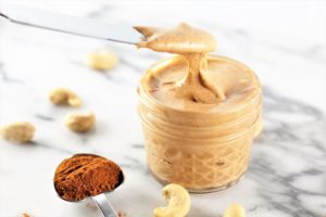 pumpkin spice roasted cashew butter with measurement of pumpkin spice on counter