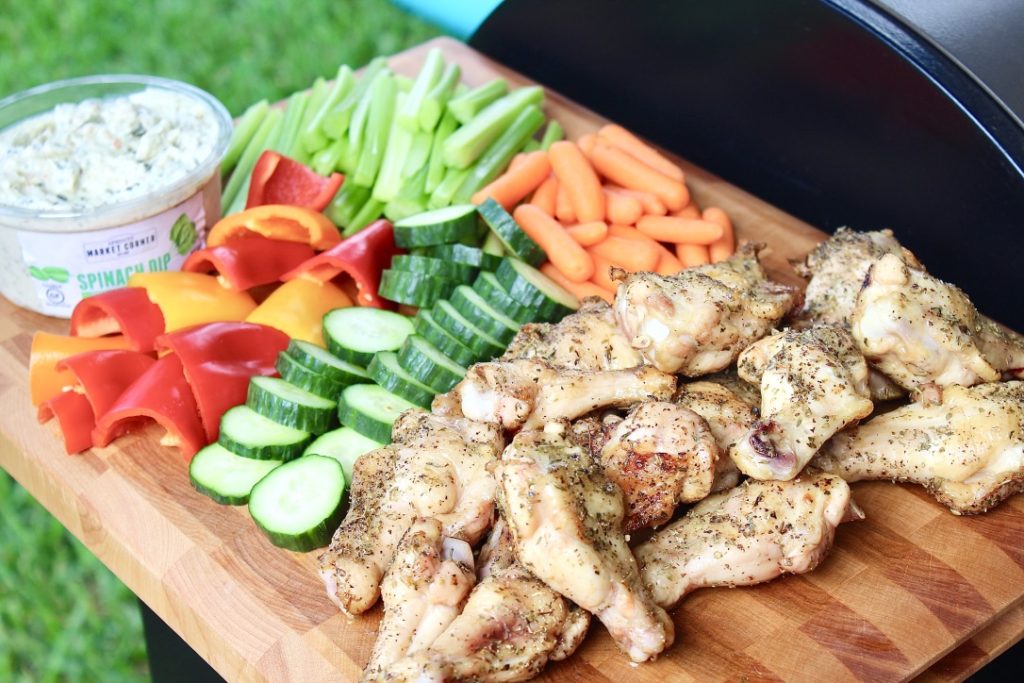 chicken wings and veggies on outdoor grill