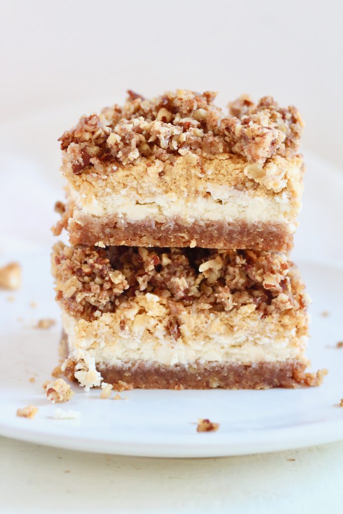 layered pumpkin cheesecake bars stacked on top of each other