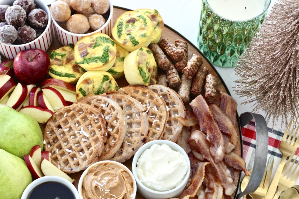 doughnut holes, waffles, and fruit on breakfast board