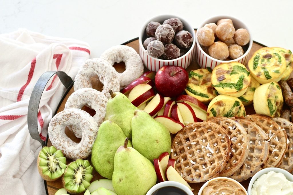 kiwi apples and pears and doughnuts on breakfast board