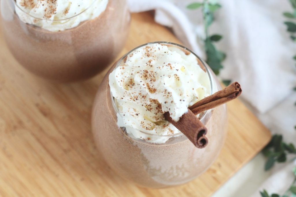 chocolate eggnog with whipped cream on wood plate