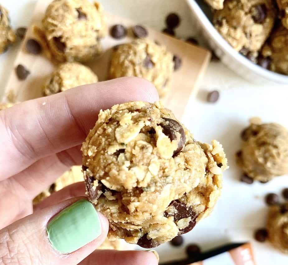 hand with green nail polish holding oatmeal protein balls