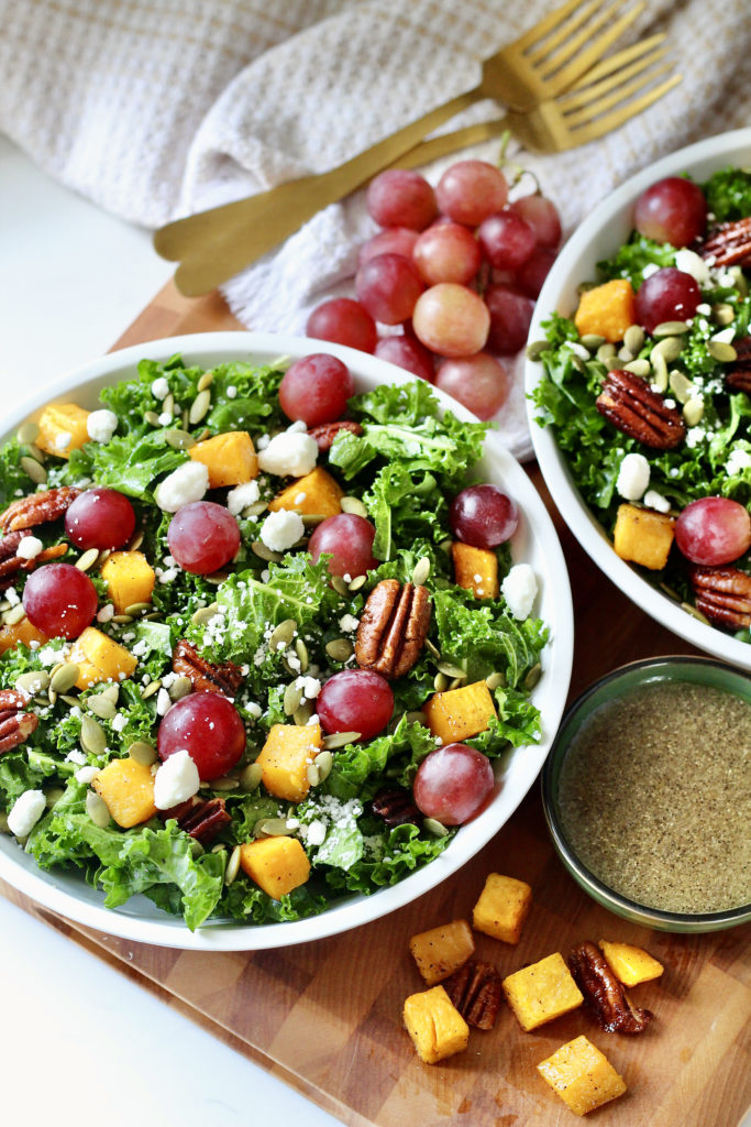 fall harvest salad in white lecreuset bowls with butternut squash and grapes