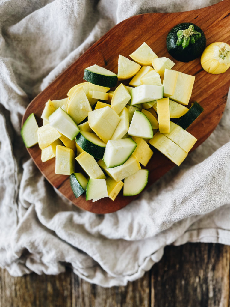 chopped yellow squash and zucchini on wood cutting board